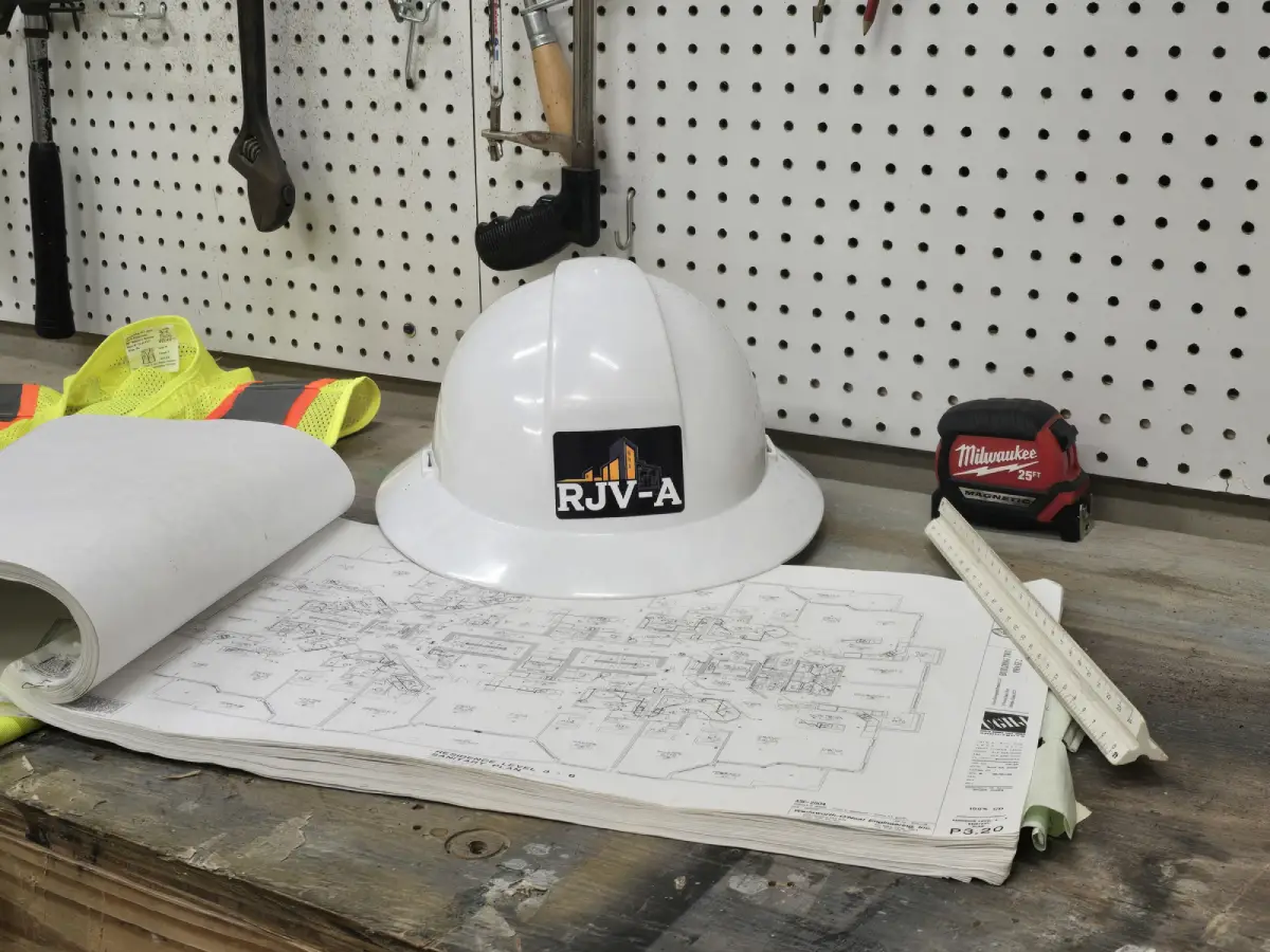 Construction helmet resting on architectural blueprints.